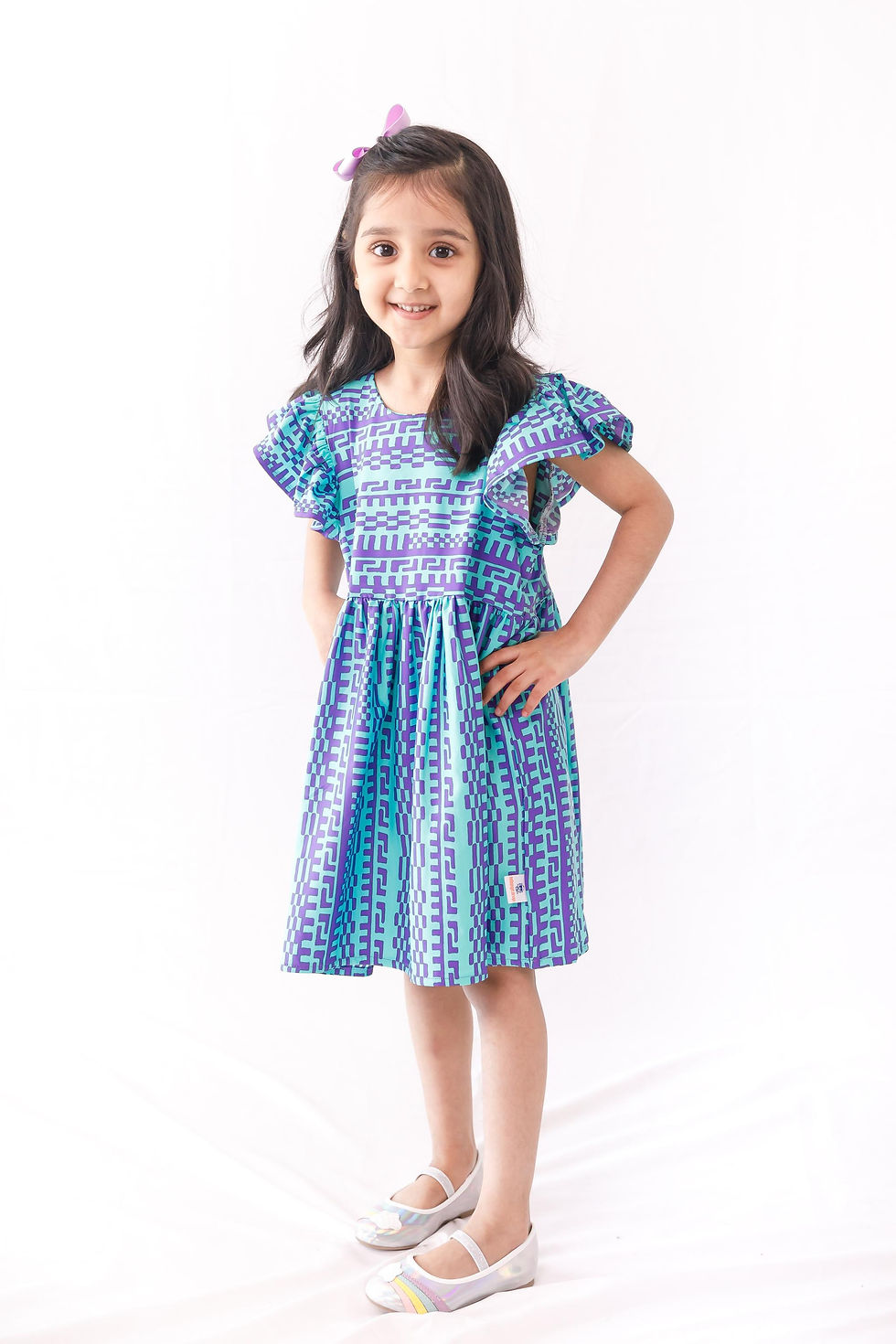 cyan geometric pattern dress, with a ruffled sleeve and a button loop at the center back
