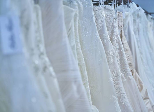 wedding dresses hanging up in a line