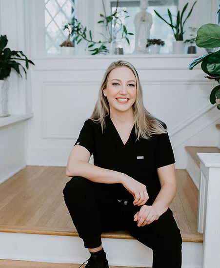 Board-certified Nurse Practitioner in black scrubs seated on stairs, promoting personalized women's health care for menopause