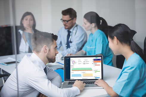 Healthcare staff collaborating around a computer displaying MediConnectr platform, showcasing Tri-Soft's dedication to seamless healthcare integration and digital solutions