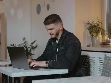 Mann arbeitet am Laptop zuhause und ist dankbar für Work Life Balance Maßnahmen.