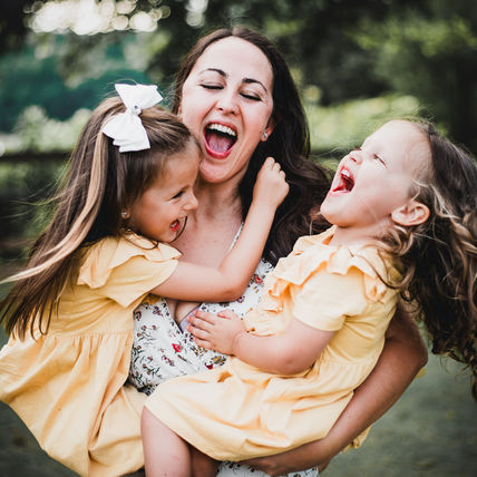 Mom being silly with two daughters outdoors