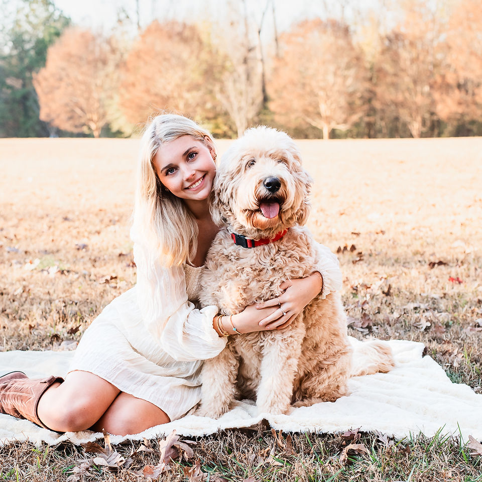 female senior laughing in the park hugging her dog