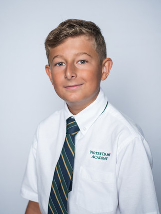 boyl posing for her school picture wearing a uniform