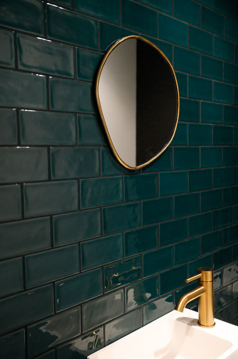 Mur en zellige vert émeraude, détails en laiton doré, miroir, mitigeur
