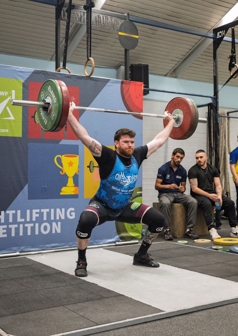 ספורטאי בוגר מבצע ניסיון תחרותי בהרמת משקולות אולימפית בליגת הבוגרים בישראל