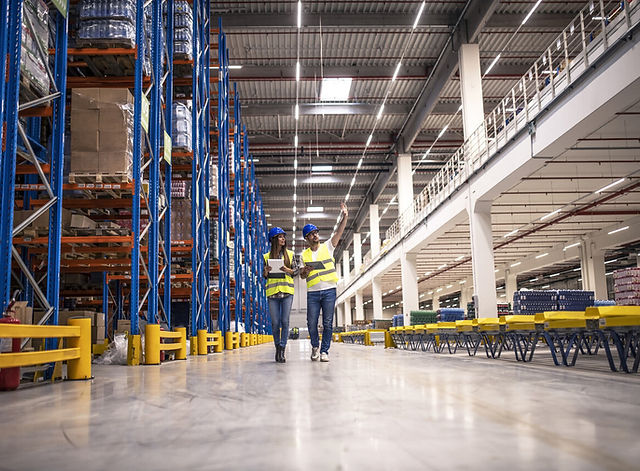 distribution-warehouse-interior-with-workers-wearing-hardhats-reflective-jackets-walking-s