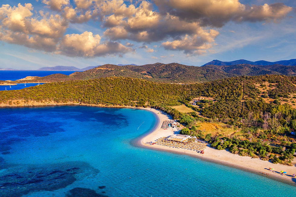 Splendida costa con spiaggia bianca, mare azzurro e montagne rigogliose.