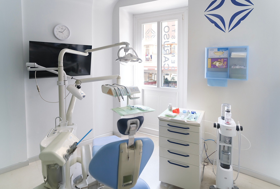 Studio dentistico moderno con poltrona blu e attrezzature per trattamenti.