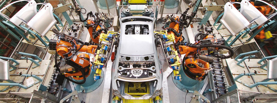 Automobile bianca in fabbrica, assemblata da robot industriali su linea di produzione.