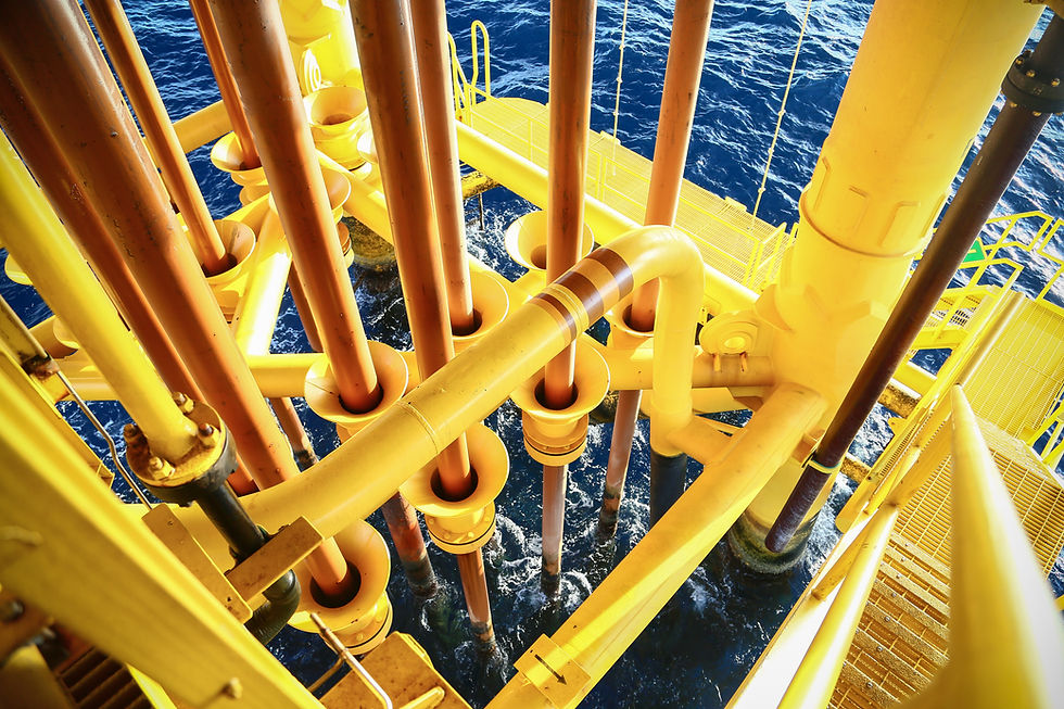 Yellow pipes and structures of an offshore oil platform at sea.
