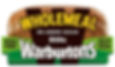 Sliced wholemeal bread loaf in packaging with "Warburtons" label. Text: "Wholemeal, No Added Sugar, 800g, High Fibre, Rich in Whole Grains." Packagig highlighting health aspects but hiding highly processed bread and additives