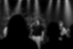 Band live, Sänger und Gitarrist auf Bühne. Banner 'DAVE COLLIDE'.