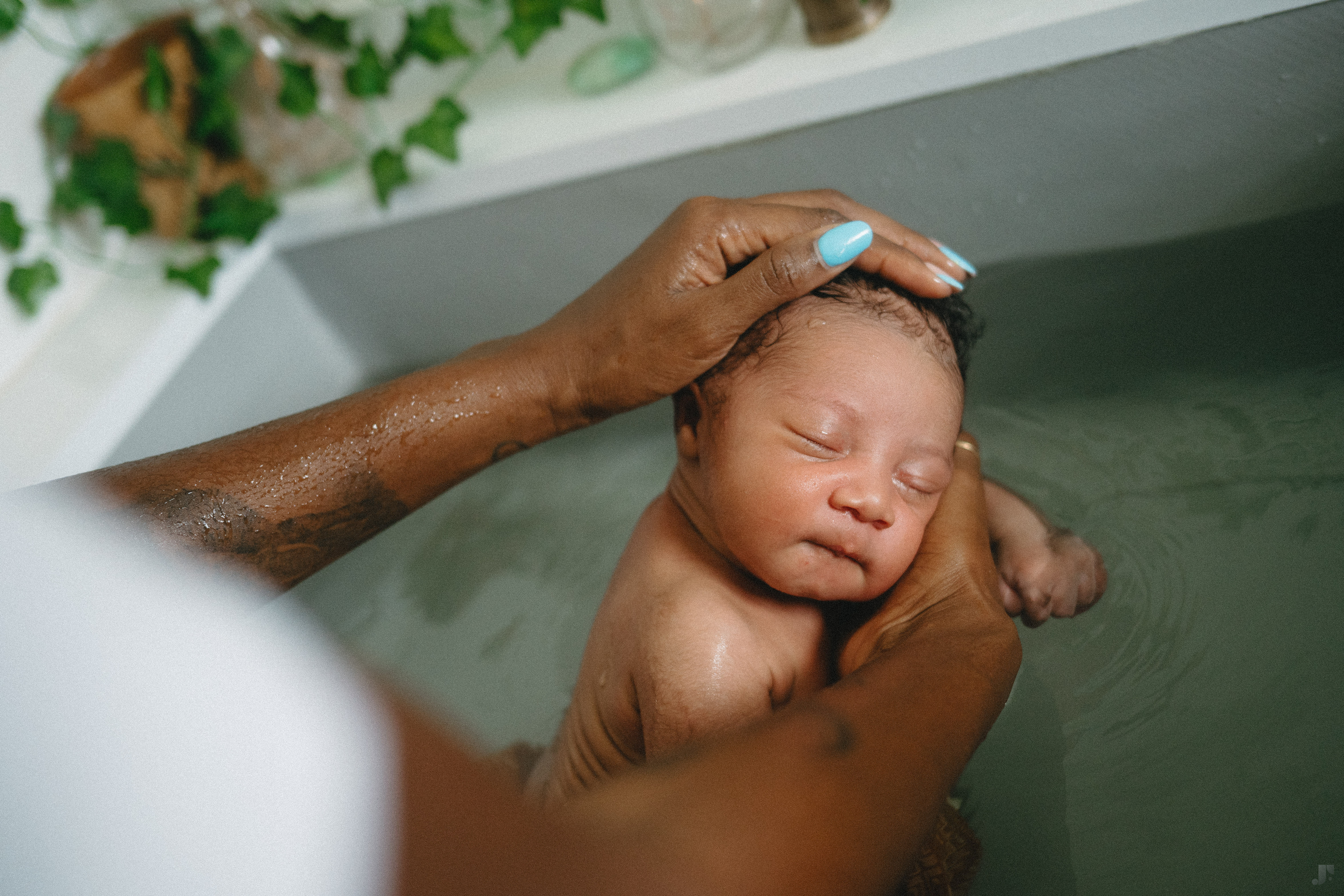 Les Mains de Yaya qui caresse la tête d'un bébé endormi lors d'un thérapeutique bain
