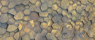 Giant's Causeway-inspired rust fragments arranged in grids, a sculpture exploring natural self-organization and pattern.