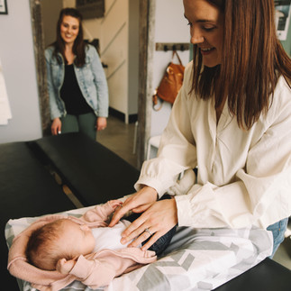 Child receiving chiropractic adjustment while mom watches