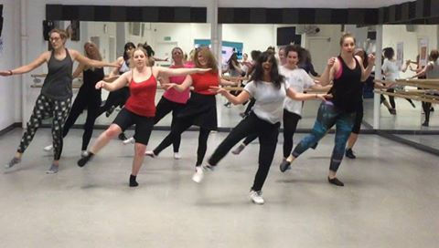 Wide angle view of a lively dance class in session