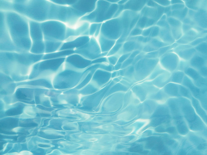 Blue water with ripples on the surface. Defocus blurred transparent blue colored clear cal