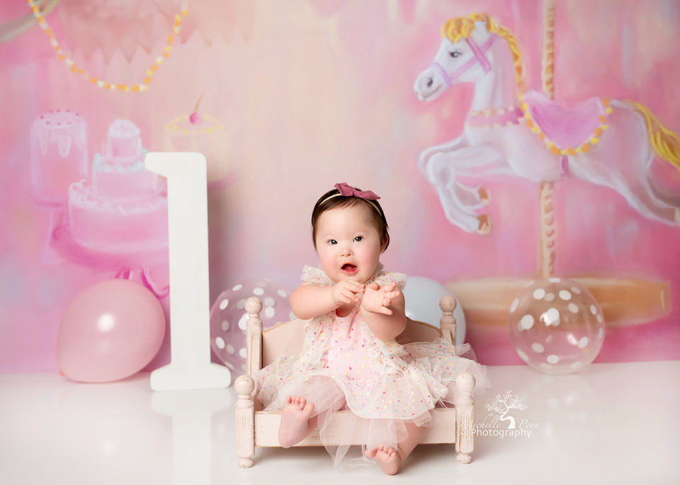 one-year photography session using carousel horse and pink balloons