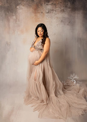 maternity session with neutral textured backdrop and beige tulle dress 