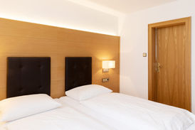 Gemütliches Doppelzimmer mit Einzelbetten und Holztür im Adler Glottertal