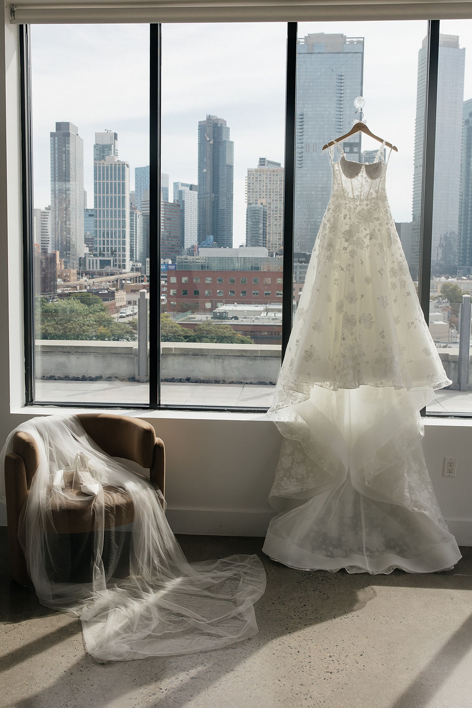 bride's wedding dress hanging on the window at the bordone lic 