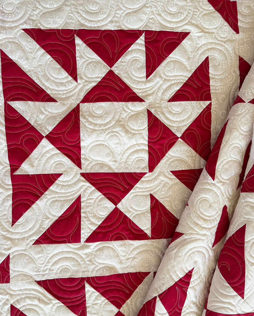 red and white star quilt with edge-to-edge quilting highlighting block design