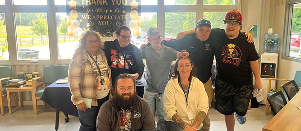 Smiling group under a Thank You banner at Home