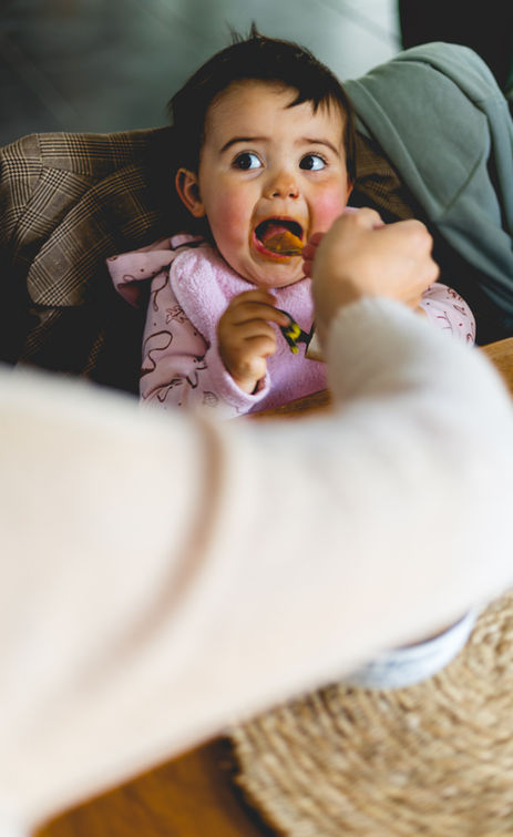 shooting photo famille - photographie lifestyle d'une maman donnant à manger à sa fille