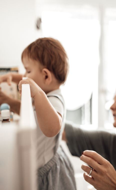 shooting photo famille - une mère et son fils sur la table à langer