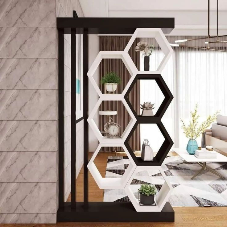 Modern living room divider with black and white hexagonal shelves holding plants and decor beside a sofa and geometric rug.