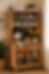 Cozy wooden coffee cabinet with espresso machine, mugs, plants, and signs reading But first, coffee and Life happens coffee helps.