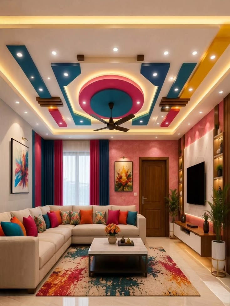 Vibrant living room with an L-shaped beige sofa, colorful pillows, patterned rug, TV wall, and geometric ceiling lights.