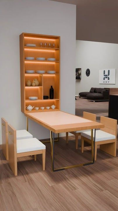 Modern dining display with light wood table and chairs, lit shelving of dishes, in a minimalist showroom.