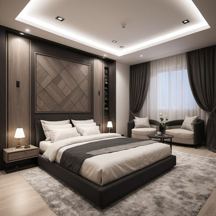Modern gray and beige bedroom with a large bed, bedside lamps, dark drapes, and two lounge chairs by a bright window.