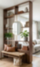 Wooden room divider shelf with round mirror, books, plants, bench, and tan pillows in a bright modern living room