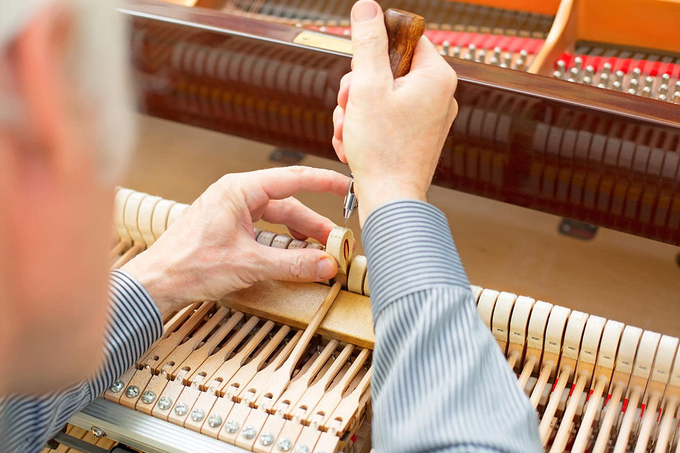 A technician voicing hammers on a piano