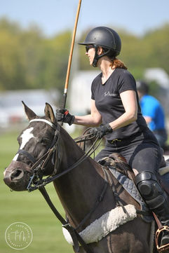 Woman playing polo on a dark horse wearing a Bedford-Jones belt
