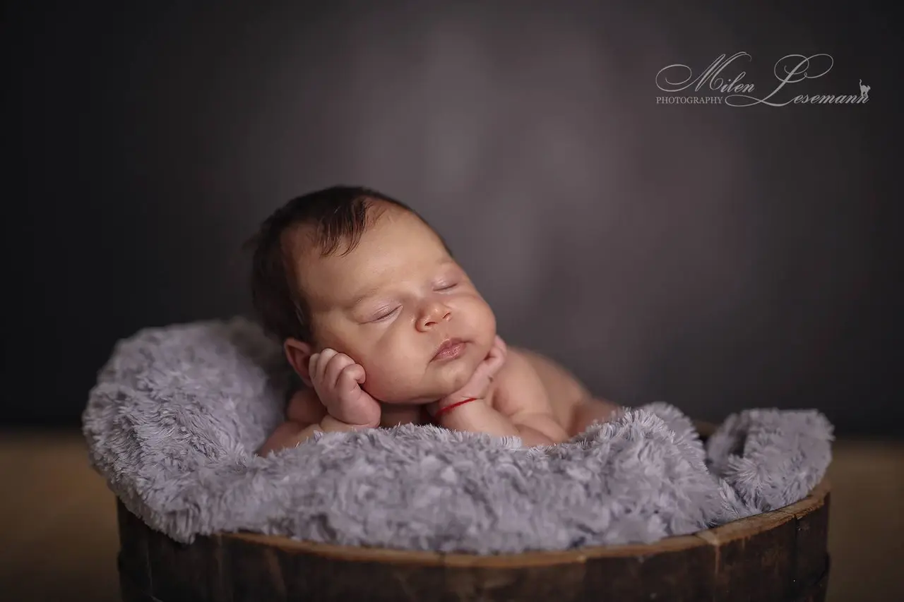 Schlafendes Neugeborenes auf lila Fell – Newborn Shooting Berlin Studio Lesemann
