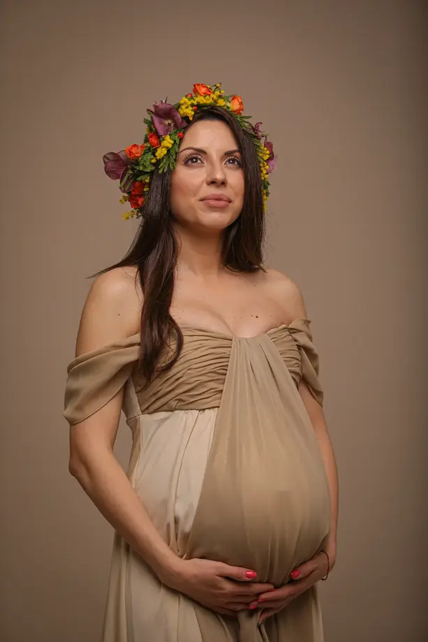 Babybauchfotos Berlin Porträt – werdende Mutter mit Blumenkranz beiges Kleid, Studio Lesemann