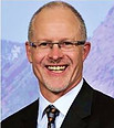 Dr Eric McCarty smiling in a photo with the Rocky Mountains as a backdrop