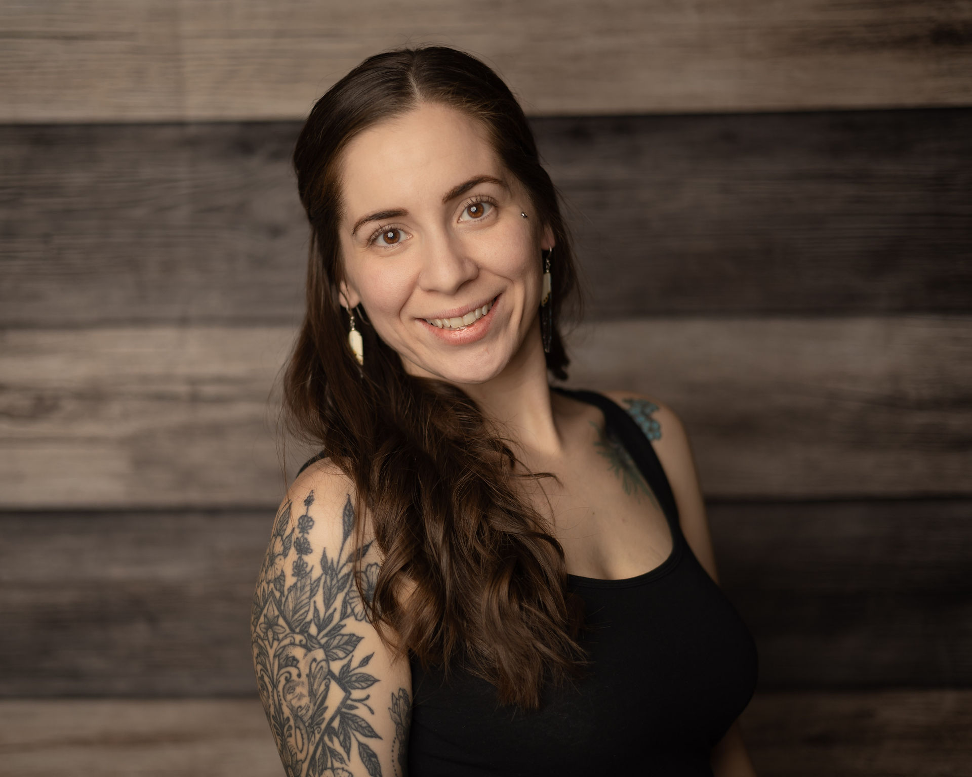 Portrait of a woman with her hands to her sides, smiling confidently.