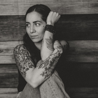 Black-and-white self-portrait of a woman with gentle, reflective expression.
