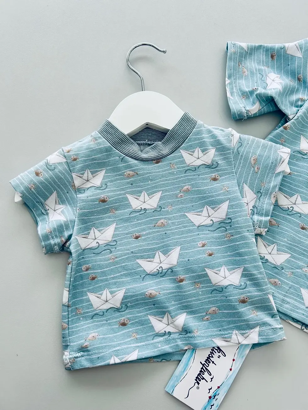 Miniaturbild: Papierboot Babyshirt mit Hose im Hintergrund, maritimer Look, hochwertiger Baumwolljersey, handgemacht für Babys und Kleinkin