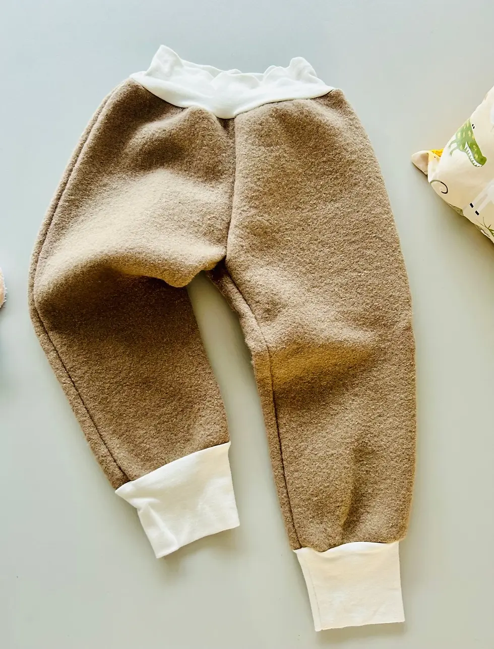 Miniaturbild: Beige Wollwalkhose mit breiten, weichen Bündchen an Bauch und Beinen, mitwachsend, atmungsaktiv und handgemacht in Hamburg.