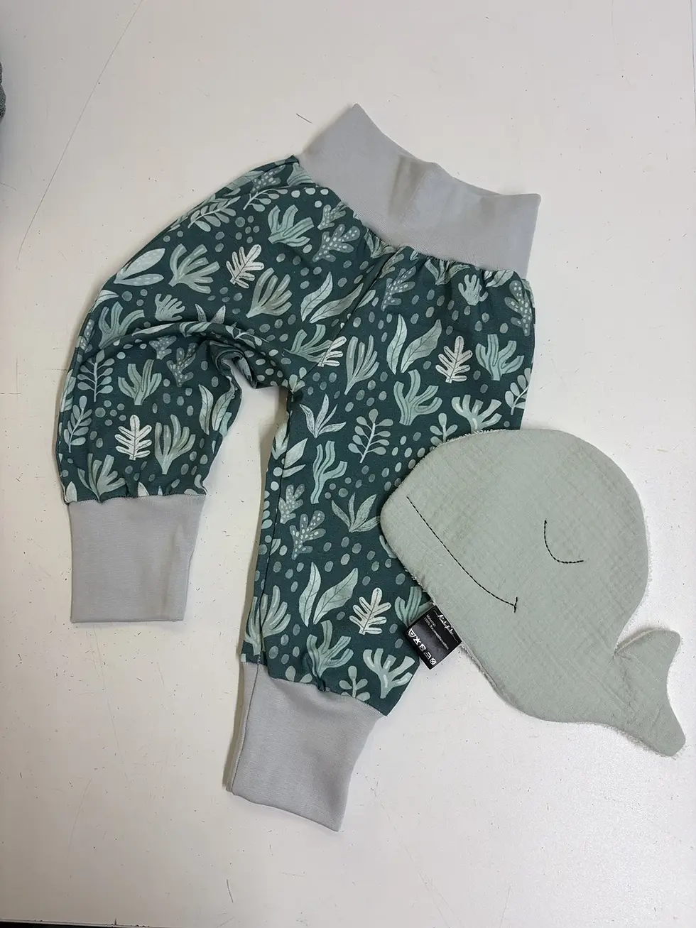 Baby sitzt und spielt in Pumphose Küstenwiese, elastische Bündchen sorgen für guten Sitz, weiche Babyhose aus Baumwolle, idea