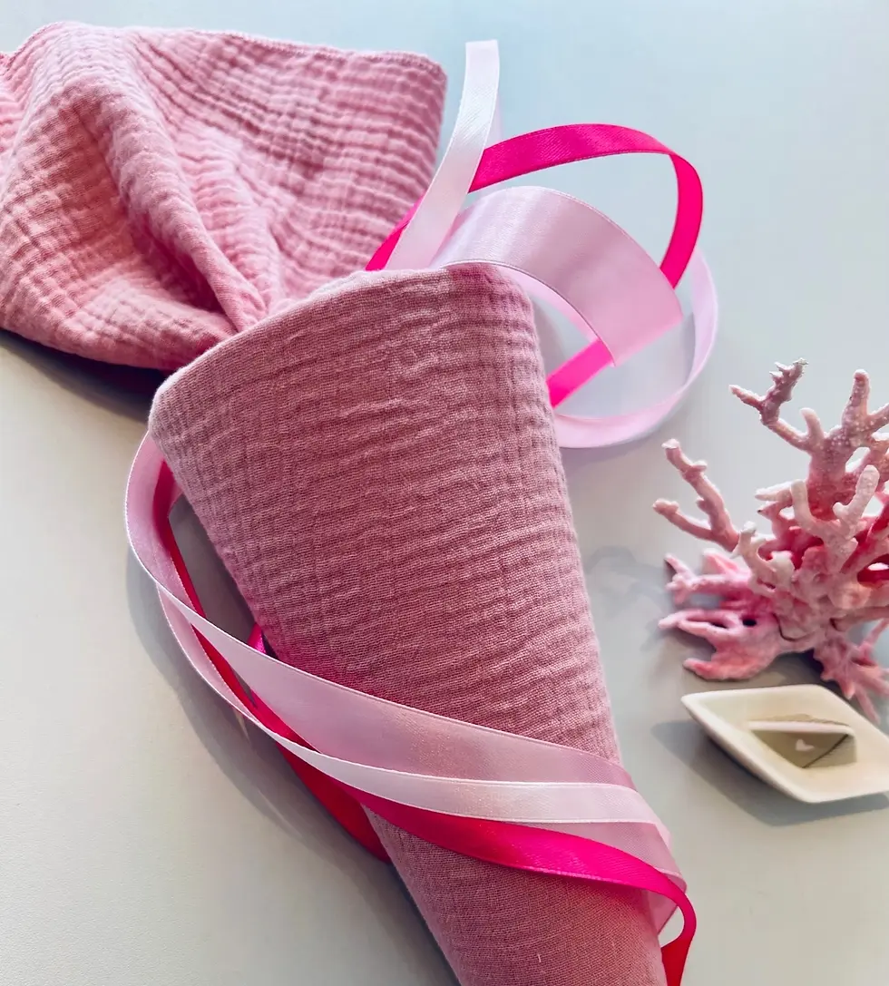 Handgemachte Baby-Schultüte aus Musselin in Altrosa mit pinken Schleifenbändern und Deko-Koralle, liebevoll handgefertigt.