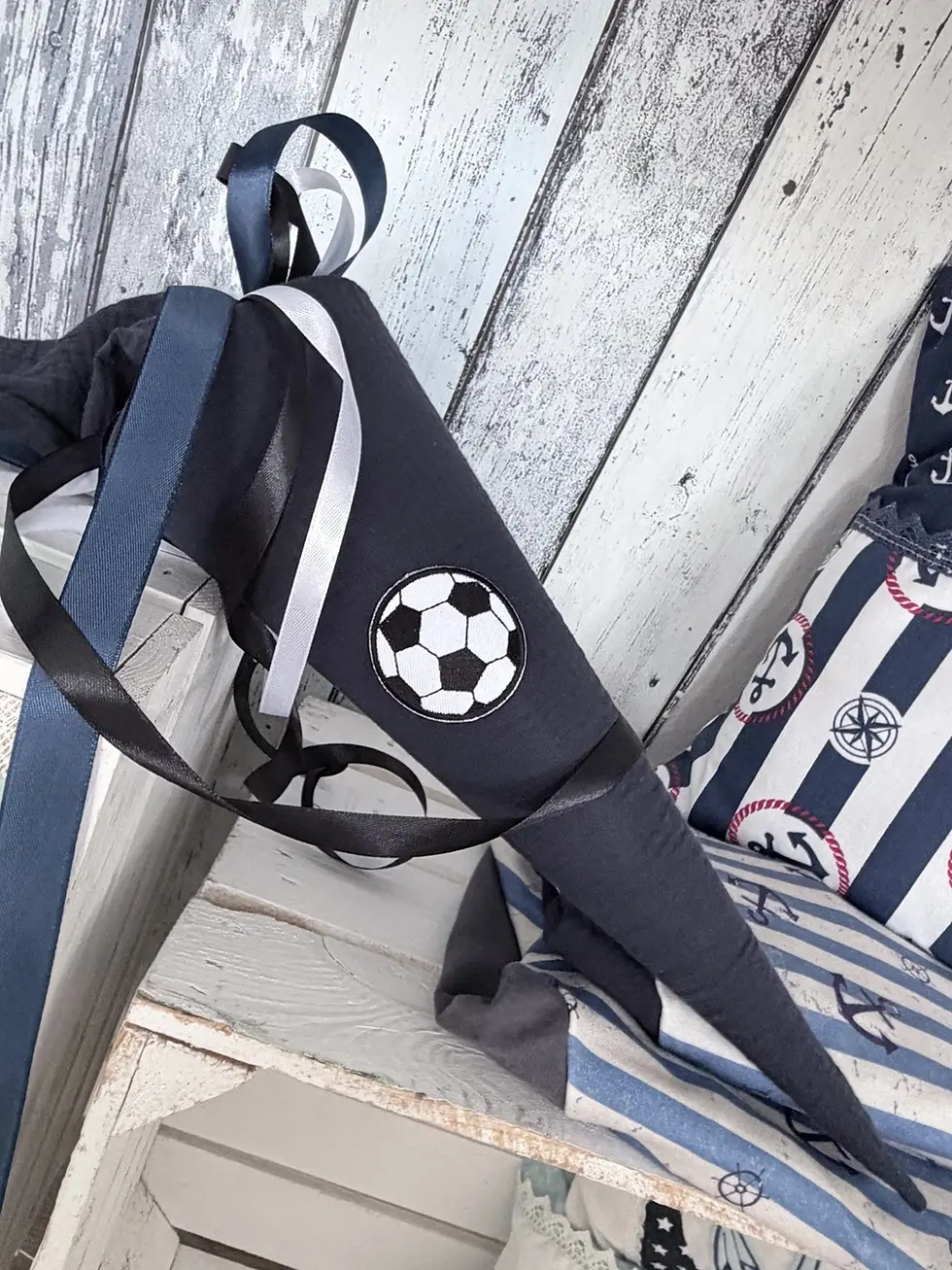 Personalisierbare Musselin Schultüte mit Fußball-Applikation in Anthrazit mit blauen, weißen und schwarzen Satinbändern.