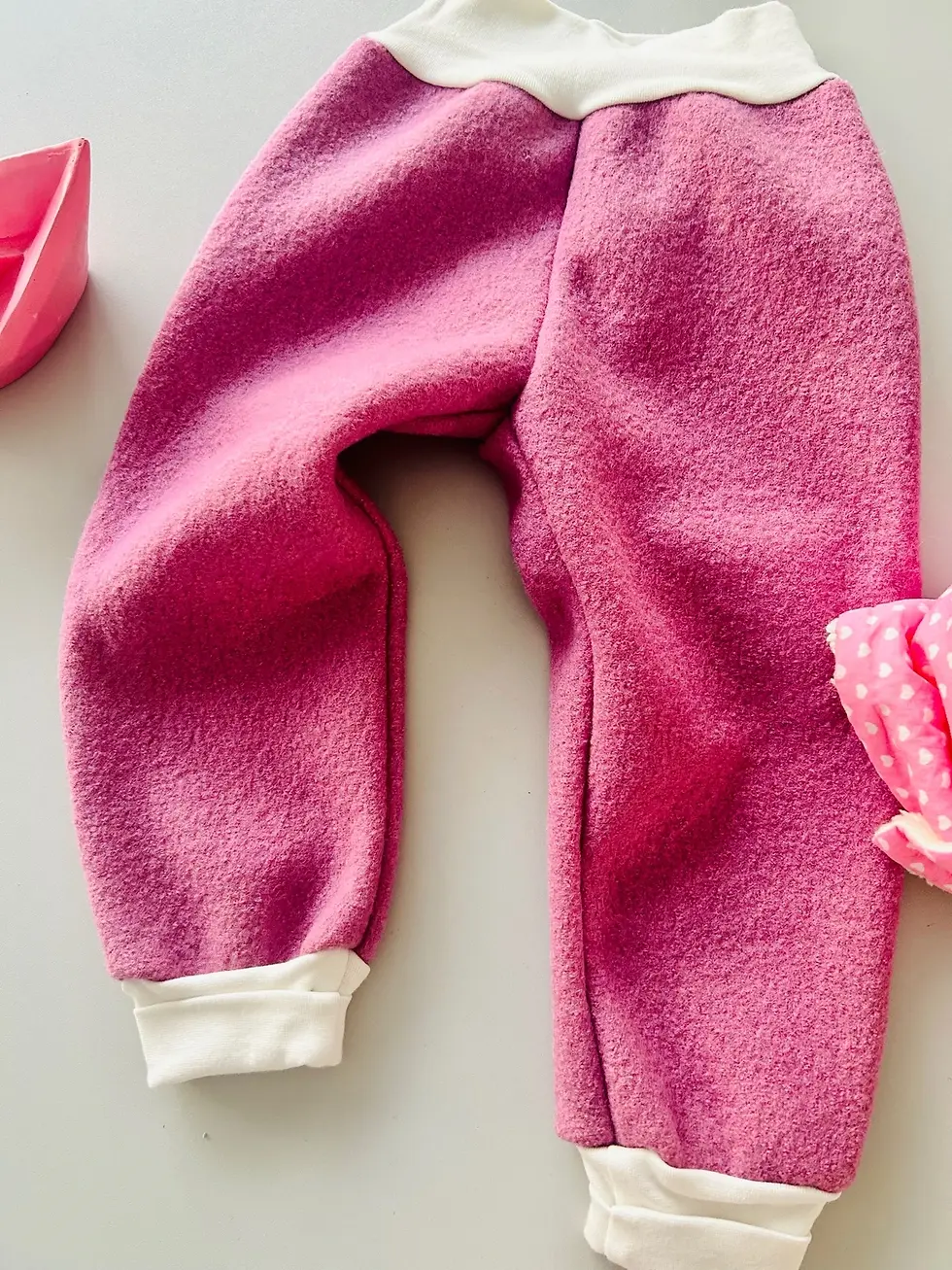 Miniaturbild: Rosa Walkhose für Babys und Kinder aus Wollwalk im Flatlay, mitwachsend, weich, robust und ideal für Herbst und Winter.