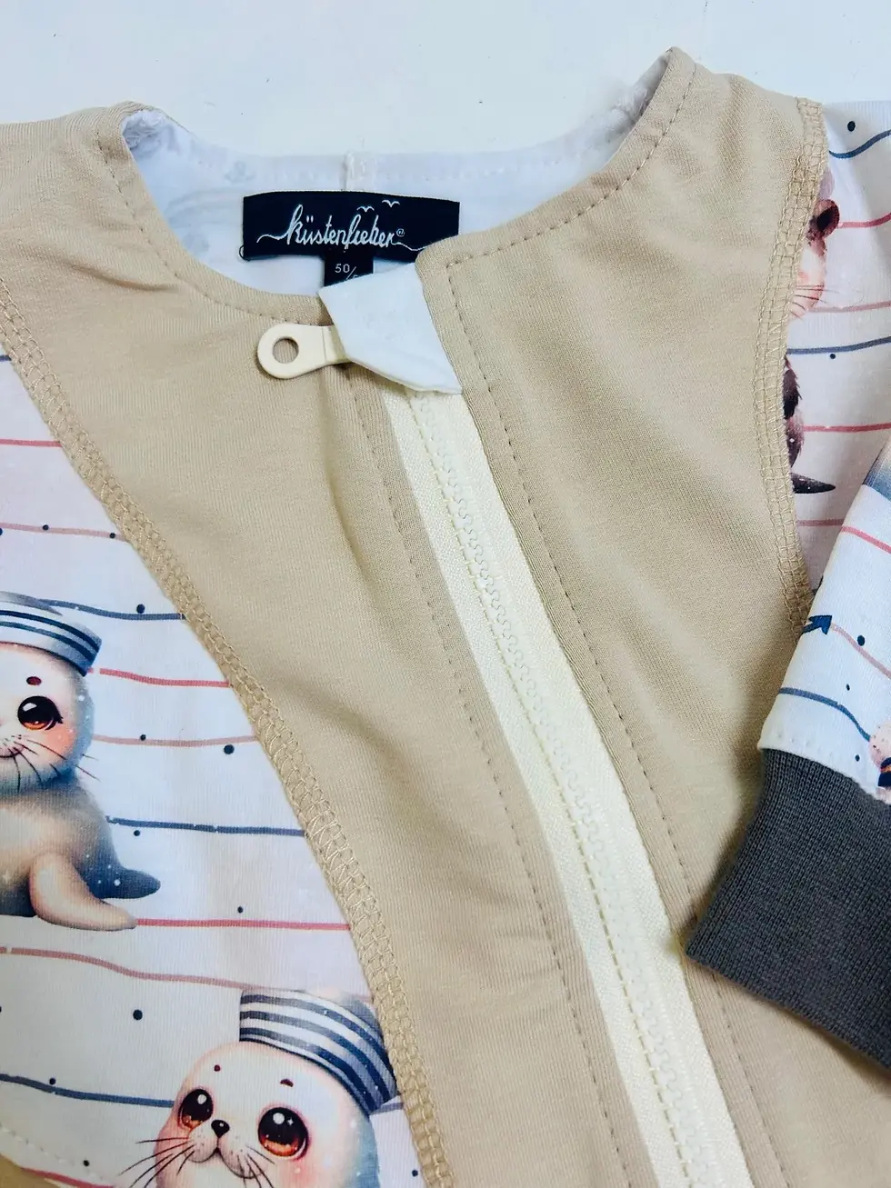 Miniaturbild: Stoffdetail French Terry mit Seehund- und Anker-Motiv, weich, elastisch und angenehm auf empfindlicher Babyhaut.